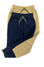 Tan and navy boys pants on a white background