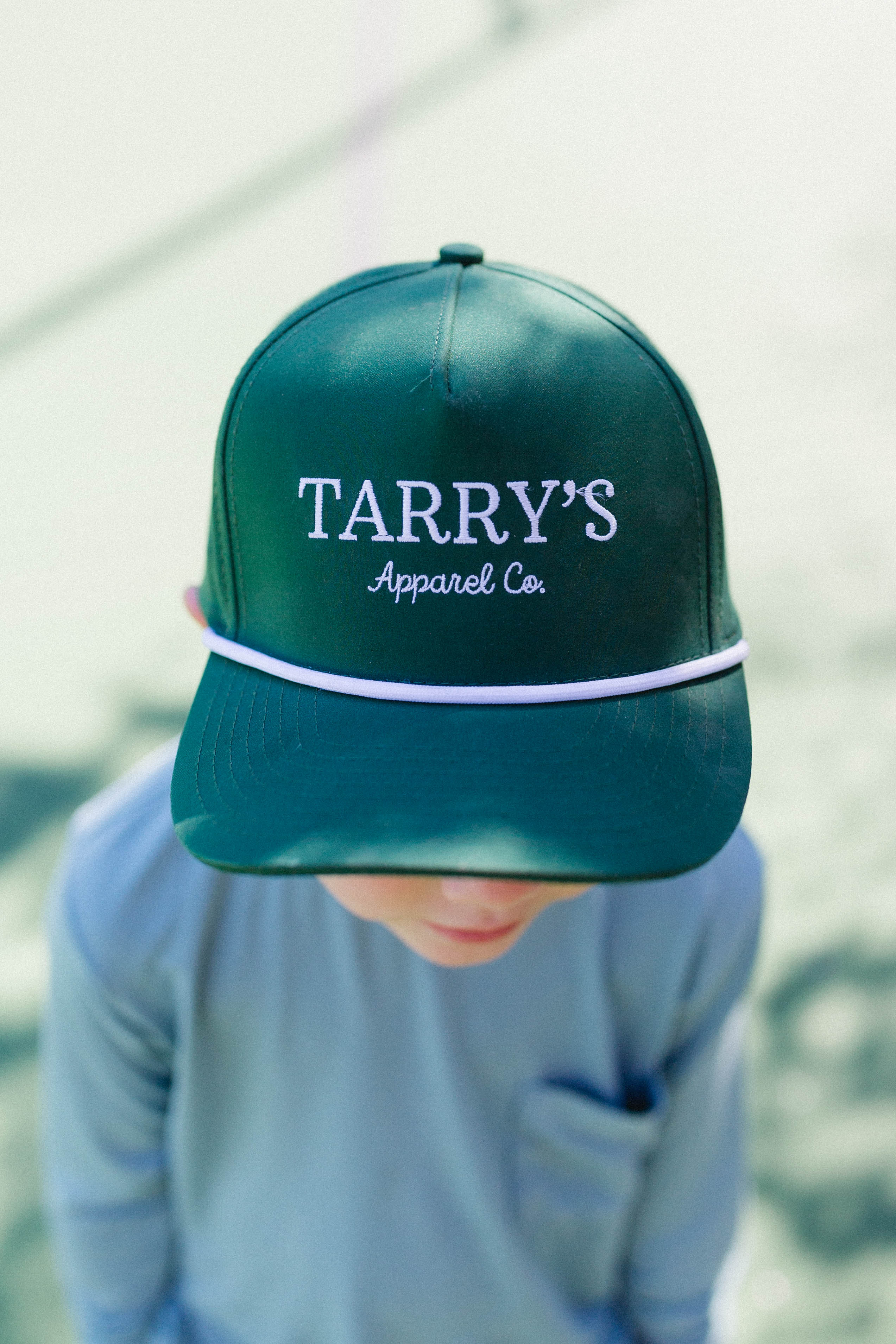 Person wearing a green cap with 'TARRY'S Apparel Co.' text on a blurred background